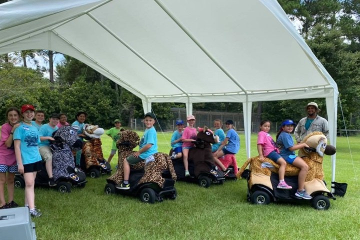 a group of people that are standing in the grass