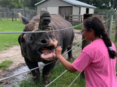 a man standing next to a fence